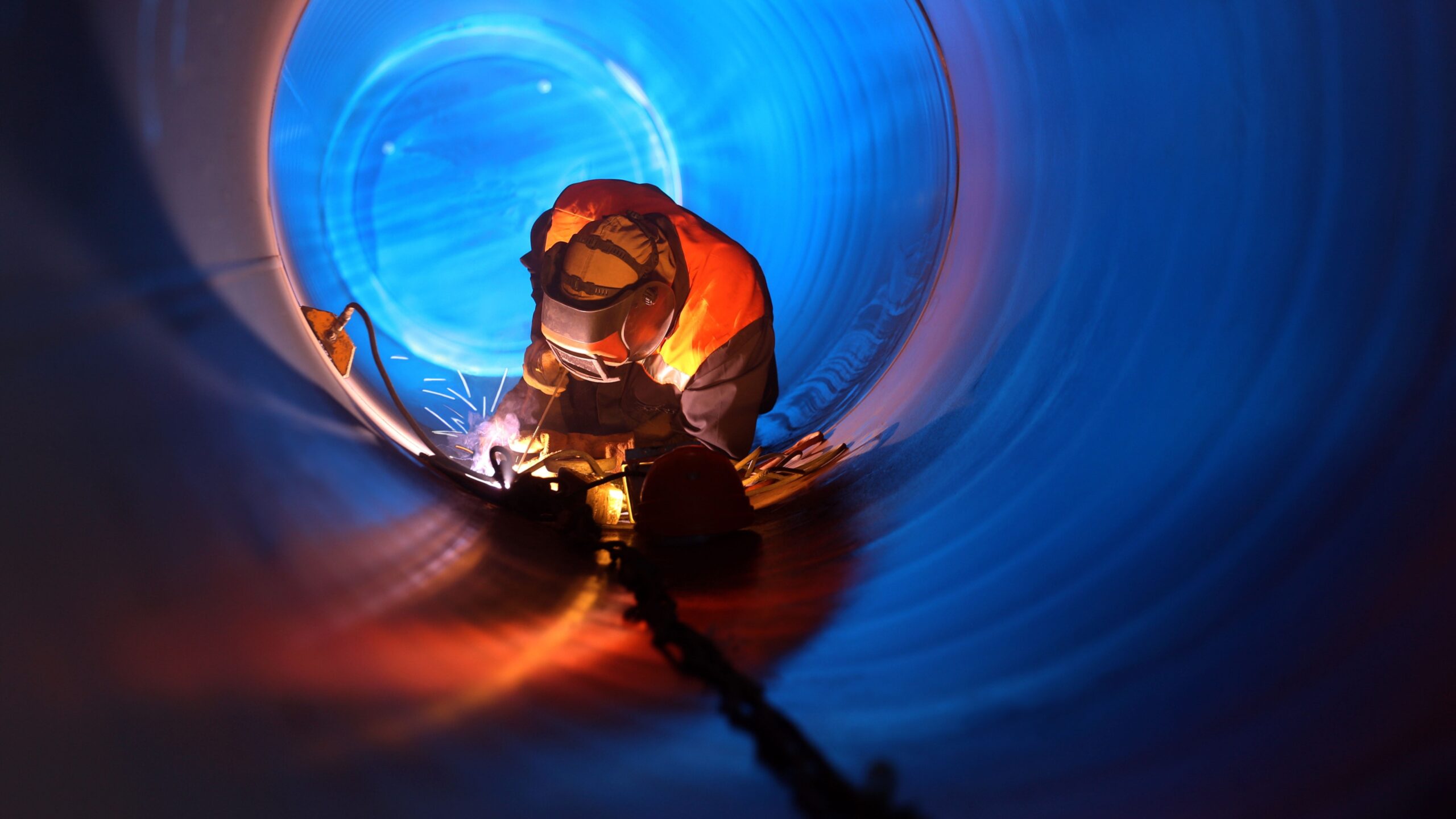 Person,Wearing,Welding,Mask,Welding,A,Circular,Pipe,From,The